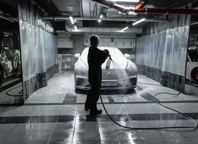 Car being sprayed with snow foam in a professional car wash bay